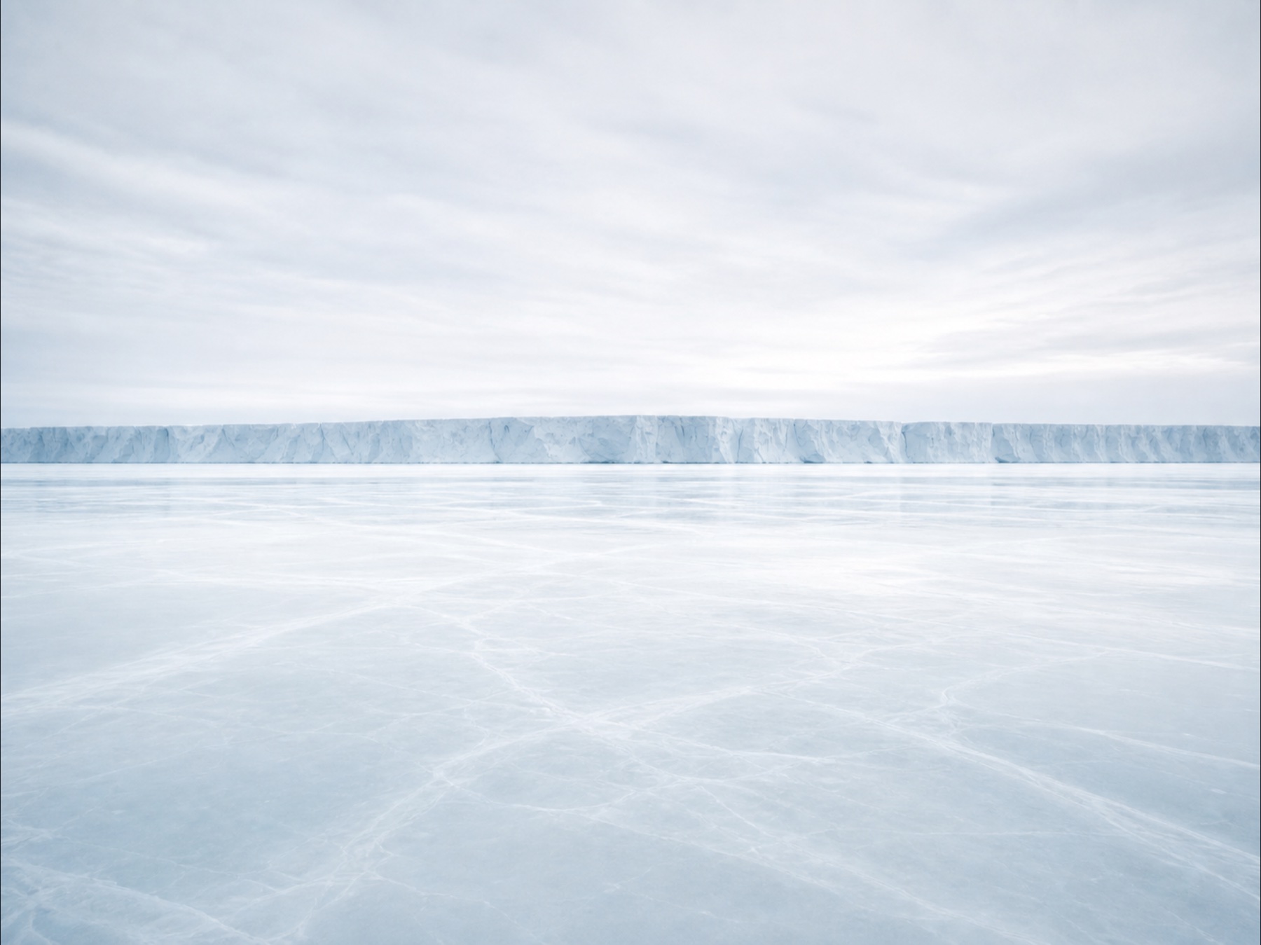 A luminous glacial shelf meeting quiet water
