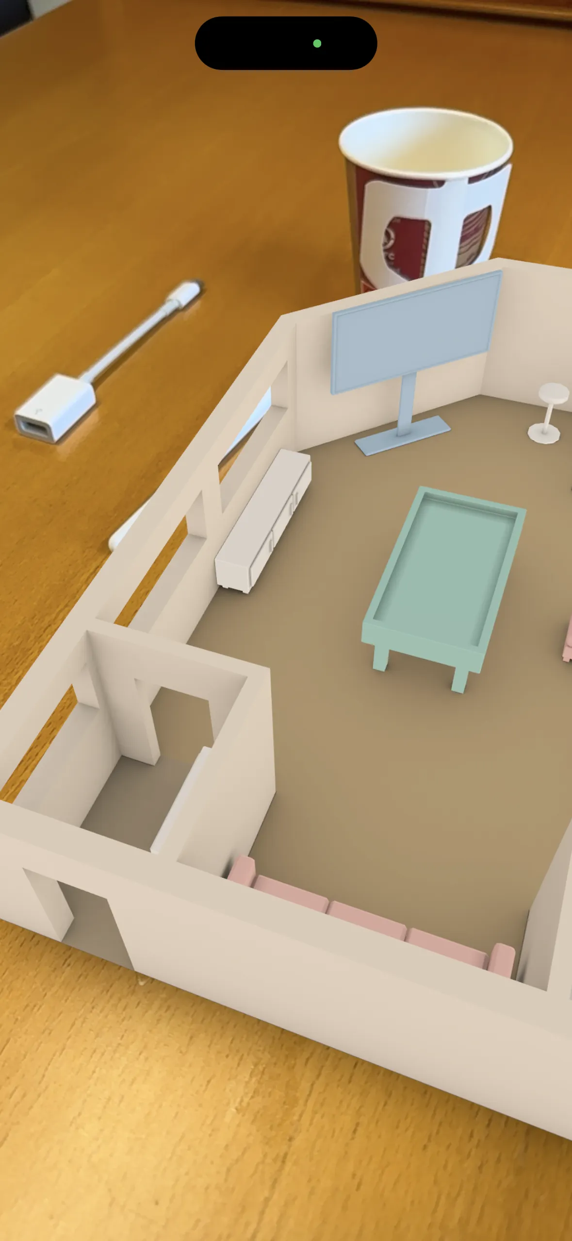The finished room standing on a real desk in augmented reality, seen on iPhone